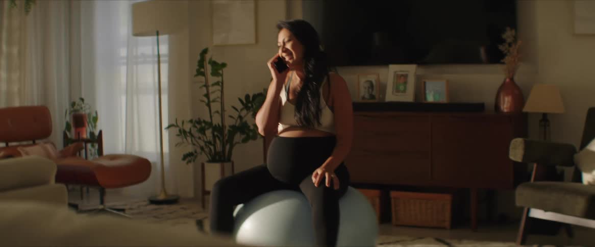 A woman is talking on the phone in her living room
