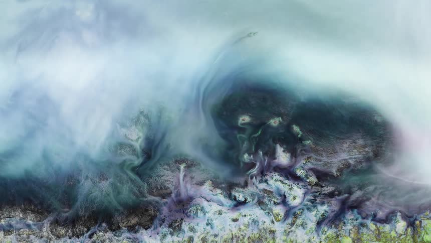 A cloud of turquoise substance floats over an organic white and lavender liquid environment as it moves