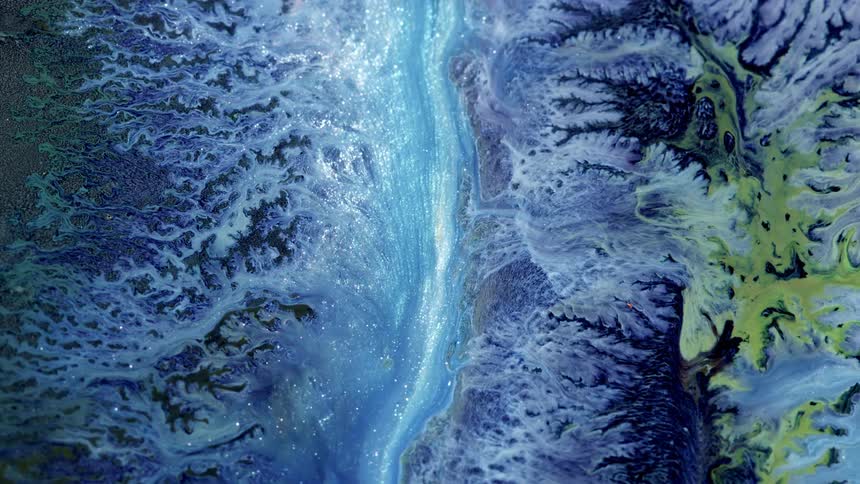 sliver and blue stream of glitter flows in this otherworldly liquid art scenario