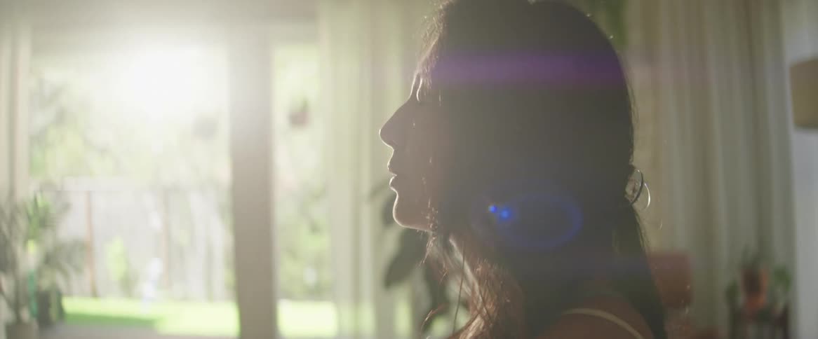 A woman in a room with her eye closed meditating