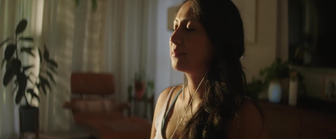A woman is listening to music and meditating