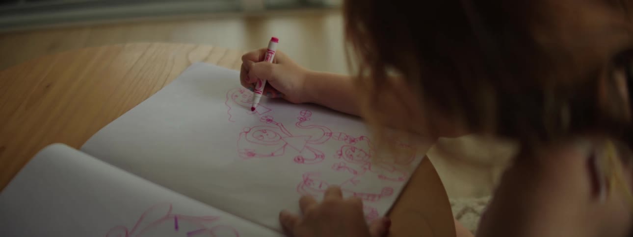 Young girl drawing on a table indoors