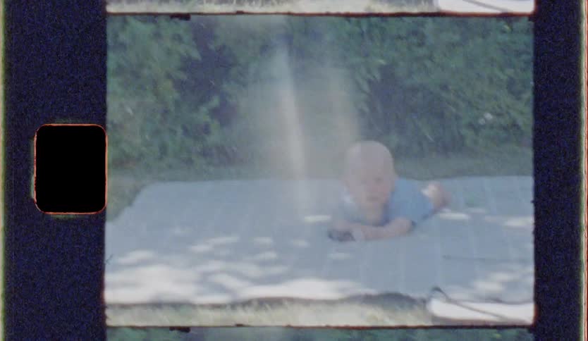 Baby crawling on a towel on the ground in the outdoor backyard