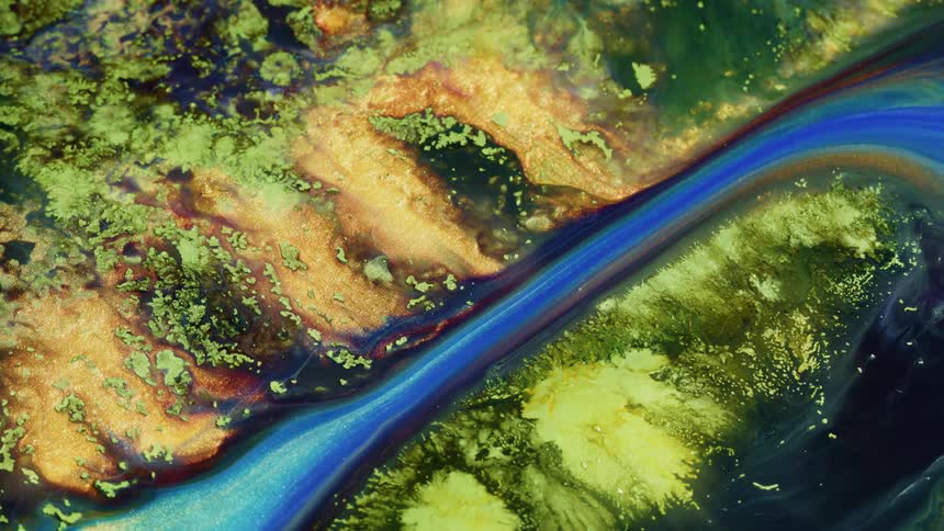 Colorful paints flowing and blending over a textured surface