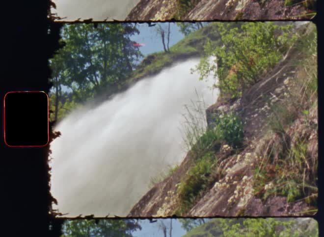 Waterfall on a rocky cliff next to vegetation