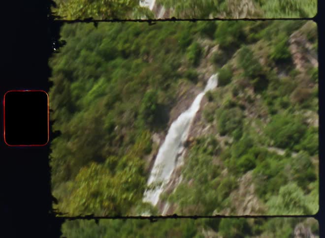 Waterfall over a rocky cliff covered in trees and vegetation