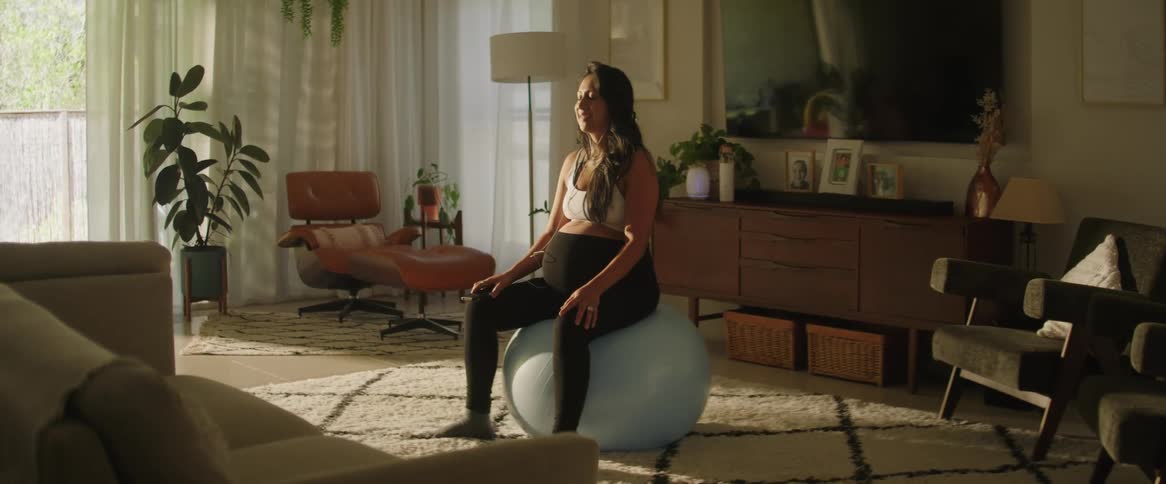 Pregnant woman practicing yoga in the living room