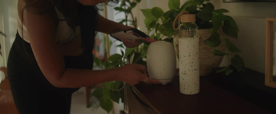 Pregnant woman at home turning on an aroma diffuser