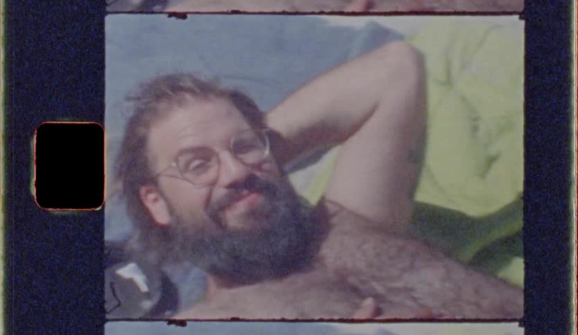 A man in a red short sleeping on the floor in the beach in a happy mood