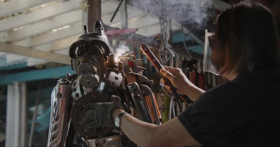 Woman building a robot out of scrap metal