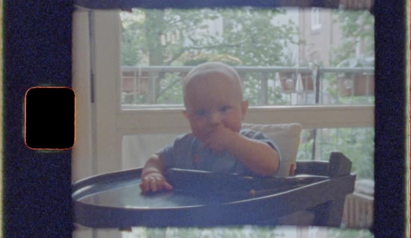 The baby is eating in the high chair
