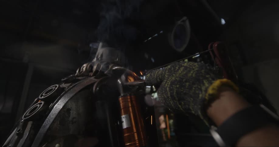 Person wearing protective gloves welding indoors