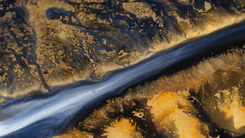 Aerial view of a flowing river in a landscape with small sand hills