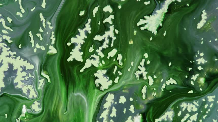 Liquid green color is being mixed together and flows like water and fog across the screen