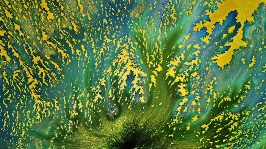 Small and obscure shaped yellow spots cover a green surface as a dark green substance with yellow glitter flows across the area in streams of blending color