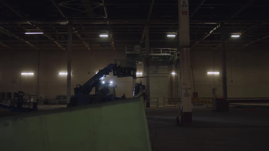 A fork lift is holding something in the warehouse