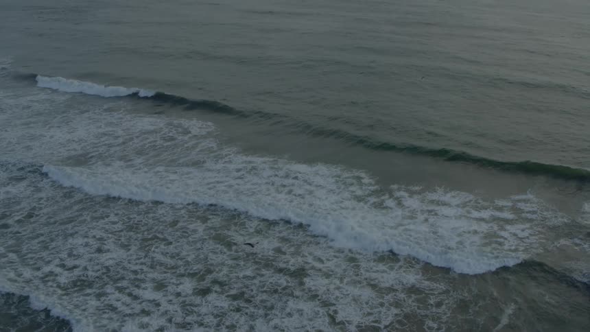 Ocean waves roll into the coast during the day