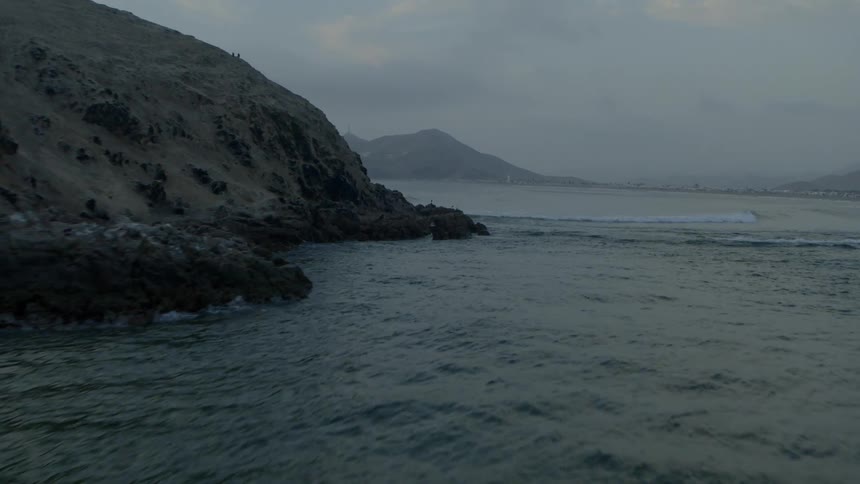 Birds fly off the rocks in the ocean