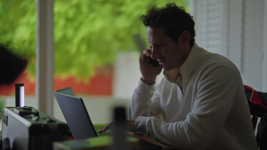 A man talks on his cell phone at his desk