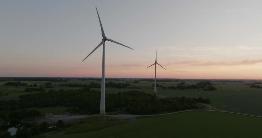 Wind turbines spin in the wind in the countryside at sunset