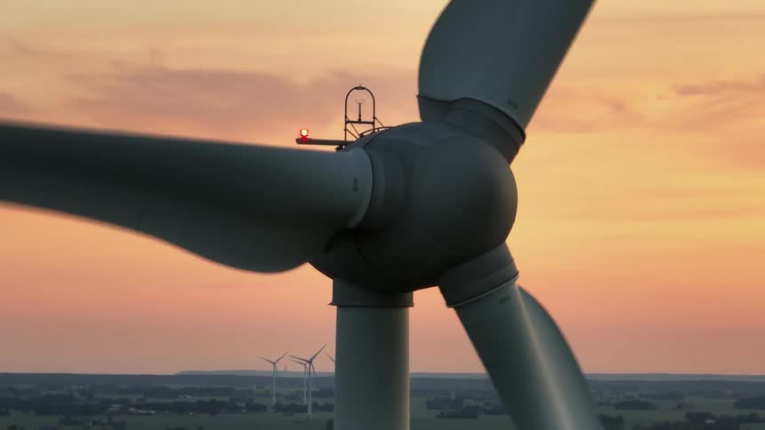 The sun is rising on the wind turbine