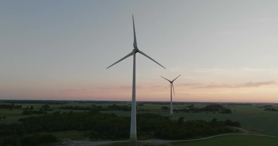 Wind turbines loom over the countryside in the evening