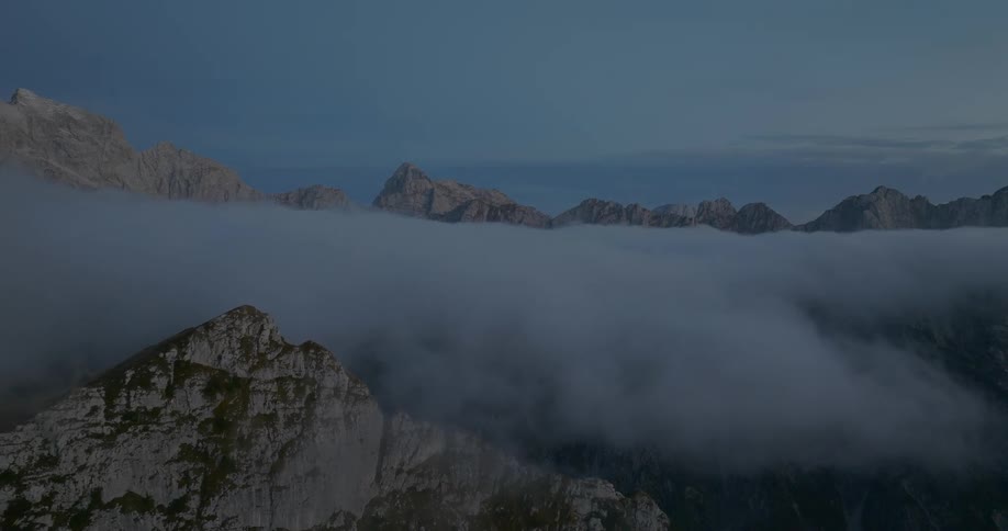 Aerial shot of a rocky mountain range covered in fog