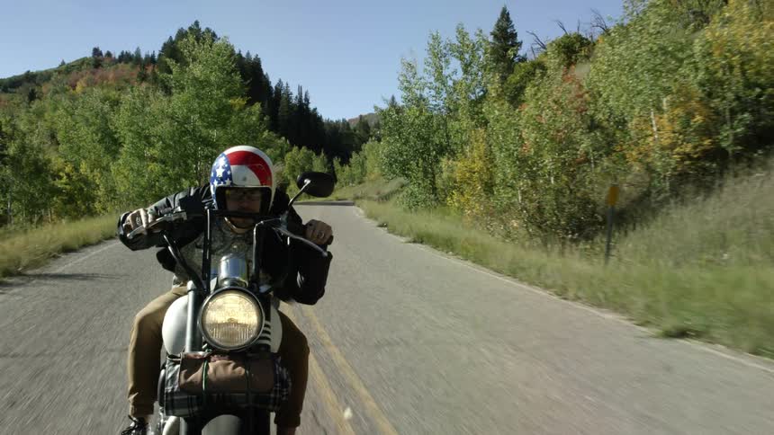 Man rides a motorcycle in a rural area
