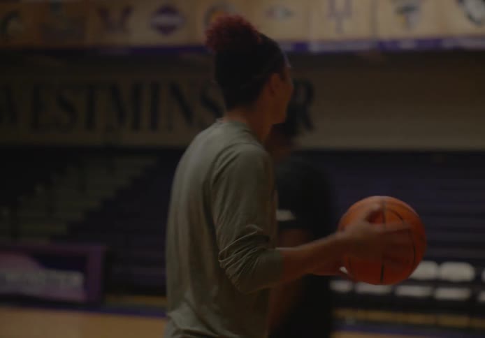 Two men on an indoors court playing basketball