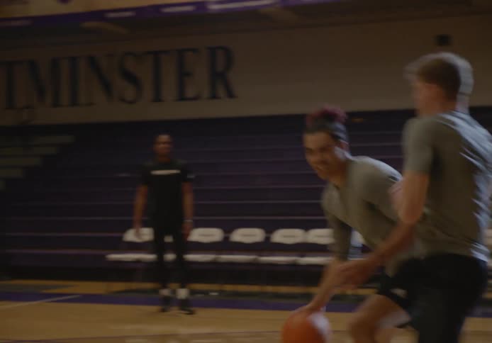 Two men compete against each other while at basketball practice