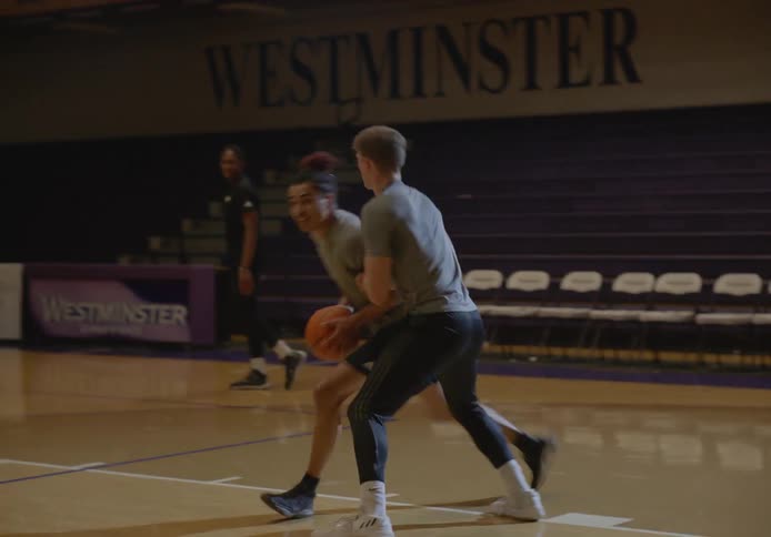 Two people play one on one basketball