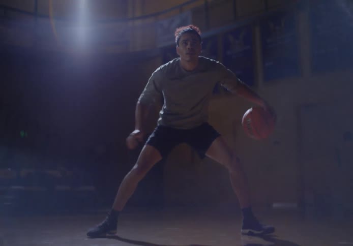 A man is dribbling a basketball fast