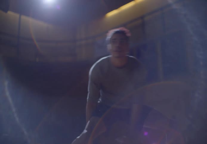 A man is dribbling a basketball under the spotlight
