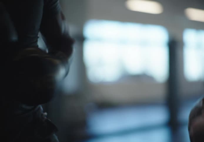 Man with boxing gloves practicing boxing with a woman he is throwing punches while she is defending