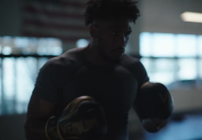 A man is practicing boxing with pads