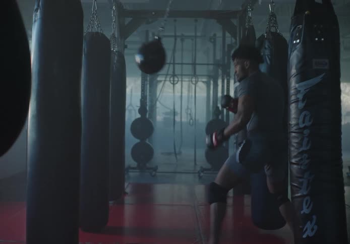 Boxer trains with swaying bag in boxing gym