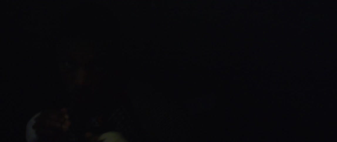 Man with fingerless glove in a dark room practicing boxing punches