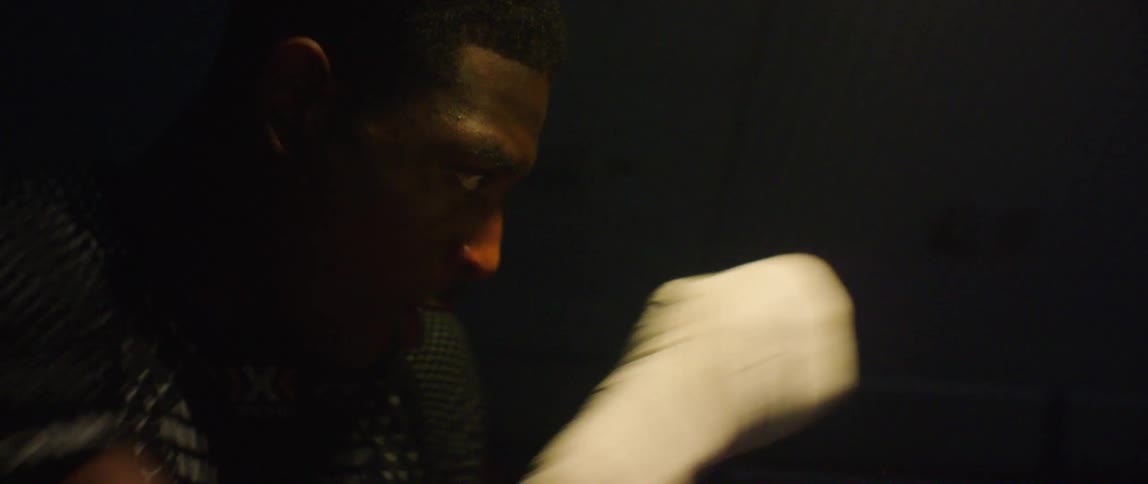 A man is shadowboxing in he dark
