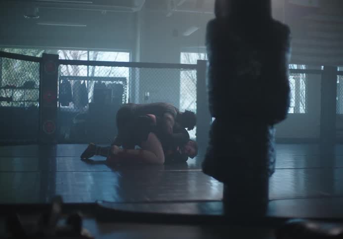Two people are wrestling in the gym