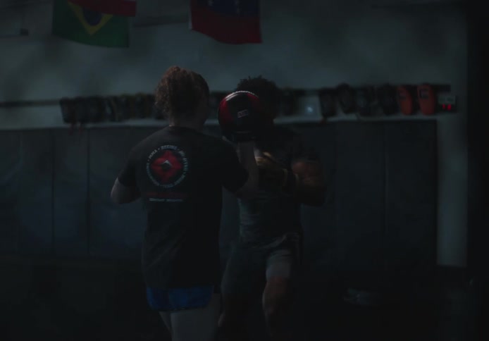 Man and woman with boxing gloves training punches and defensive techniques in a gymnasium