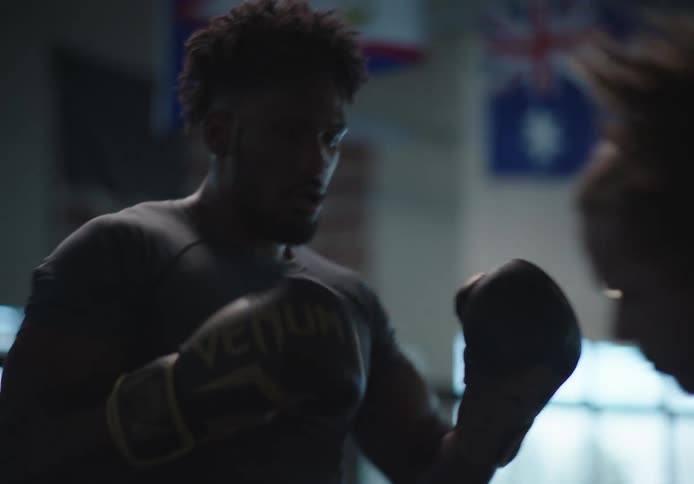 Two men are practicing boxing in the gym