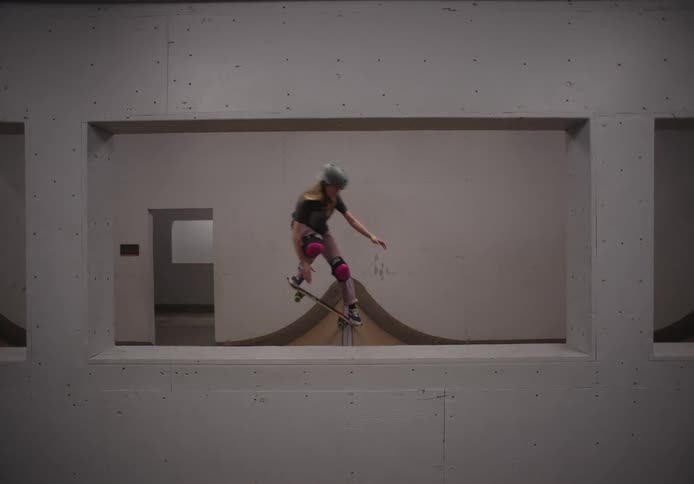 A girl is skateboarding indoors