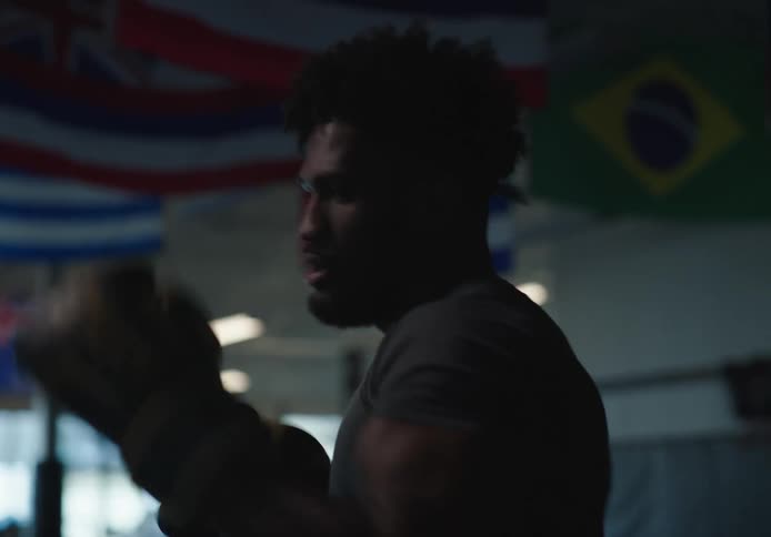 A man is kicking pads in the gym
