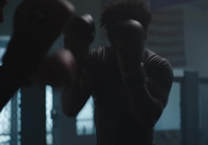 Two men with boxing gloves engaging in a boxing match at a gymnasium