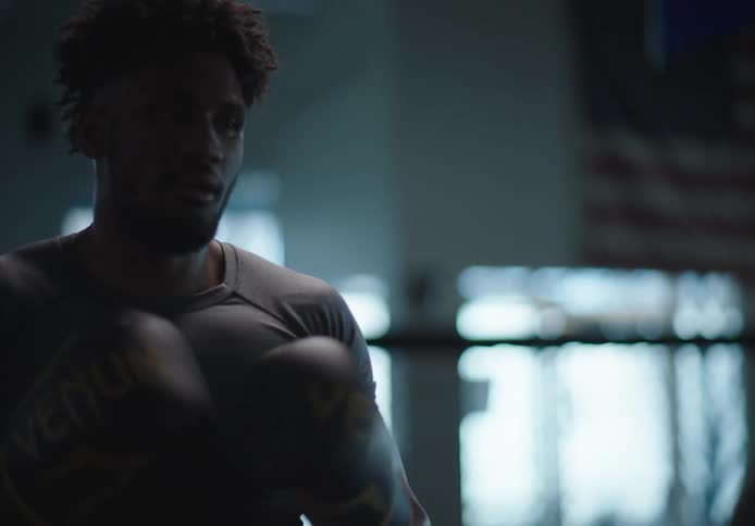 Man with boxing gloves practicing boxing with a woman in a gymnasium
