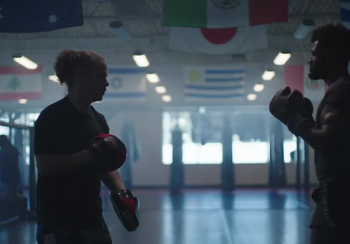 Two men are sparring in the gym