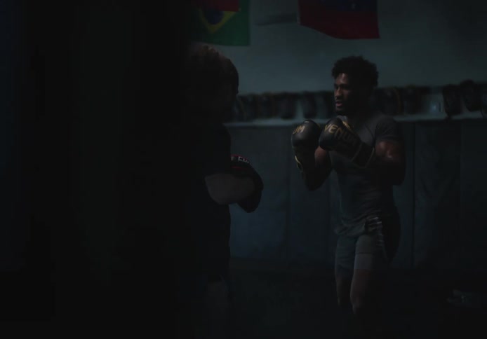 Two men are sparring in the gym