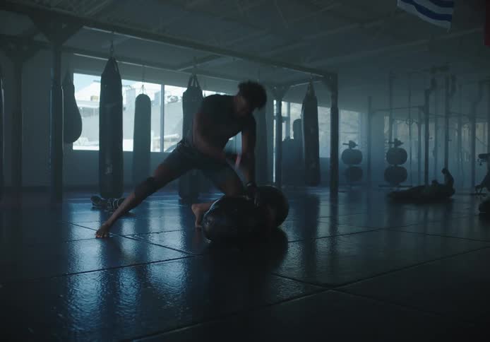 A man is punching a heavy bag on the ground