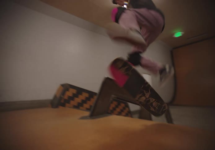 A girl rides a skateboard up a staircase in a building