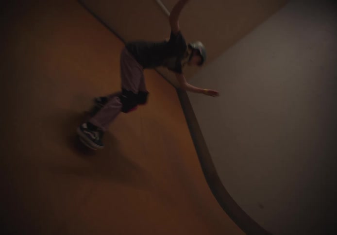 A girl is skateboarding on the indoor ramps